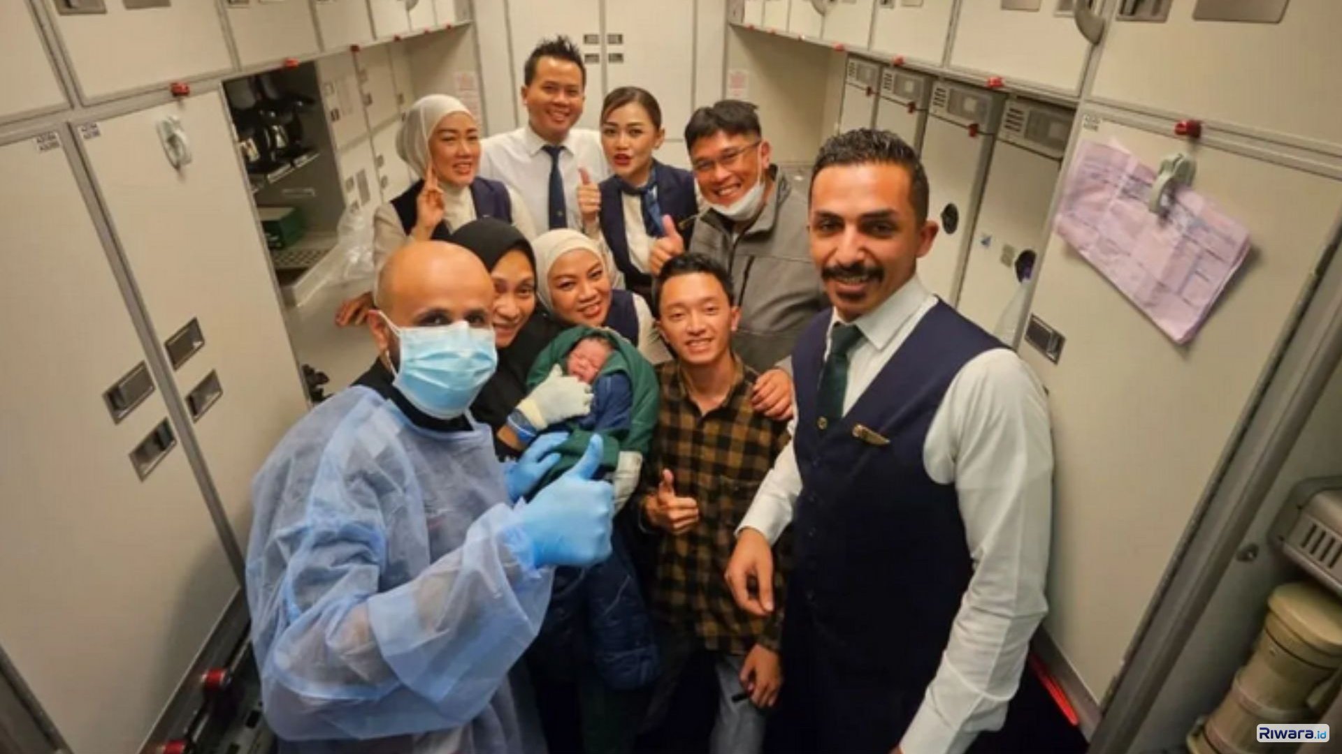 Penumpang dan kru pesawat berfoto bersama setelah proses persalinan darurat berhasil dilakukan di dalam pesawat maskapai Saudia Airlines dalam penerbangan rute Jeddah&ndash;Jakarta.